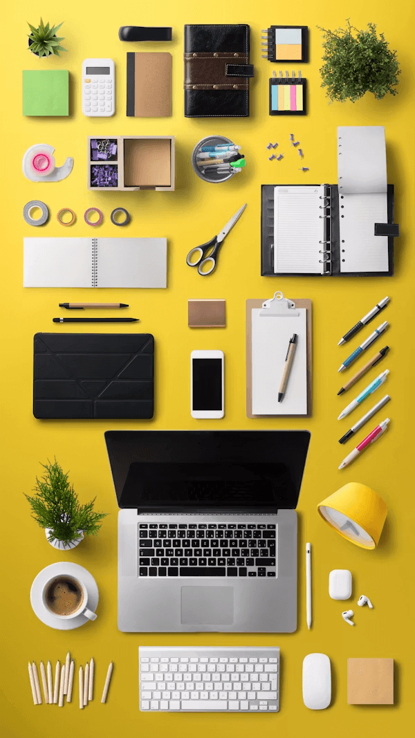 Stationery and office accessories arranged on a yellow background